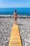 Woman Standing On Wooden Path At  Sea