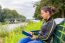 Dutch Woman On Bench At Water Reading Book