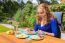 Young Caucasian Woman Eating Breakfast In Garden