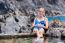 Caucasian Woman Sunbathing On Rocks At Natural Water