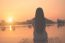 Silhouette Of Relaxing Young Woman On Wooden Pier At The Lake In Sunset