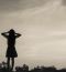 Silhouette Of Woman Praying Over Beautiful Sky Background