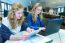 Two Dutch Girls Working On Computer And Tablet In Computer Class