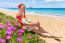 Dutch Woman With Pink Flowers On Sandy Beach With Blue Sea At Co