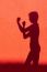 Silhouette Of Woman Showing Fists On Red Wall