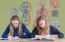 Two Dutch Teenage Girls Reading Text Books With Biology Wall Cha