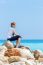 Caucasian Woman Sitting On Rocks At Coast Near Sea