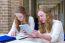 Two Dutch Teenage Girls Studying In Long School Corridor