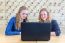 Two Teenage Girls Looking At Computer In Chemistry Lesson