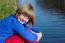 Young Girl Sitting At Waterfront