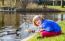 Young Girl Feeding Ducks With Bread