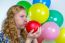 Girl Blowing Inflating Colored Balloons