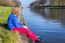 Young Girl Sitting At Waterfront Of Canal