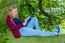 Dutch Girl Lying Reading Book In Green Tree