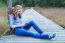 Girl Sitting On Wooden Path In Nature Phoning Mobile