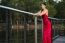 Beautiful Young Woman In The Gardens Wearing A Long Silk Red Dress