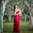 Beautiful Young Woman In The Gardens Wearing A Long Silk Red Dress