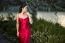 Beautiful Young Woman In The Gardens Wearing A Long Silk Red Dress