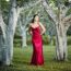 Beautiful Young Woman In The Gardens Wearing A Long Silk Red Dress