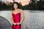 Beautiful Young Woman In The Gardens Wearing A Long Silk Red Dress