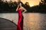 Beautiful Young Woman In The Gardens Wearing A Long Silk Red Dress