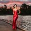 Beautiful Young Woman In The Gardens Wearing A Long Silk Red Dress