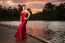 Beautiful Young Woman In The Gardens Wearing A Long Silk Red Dress