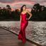 Beautiful Young Woman In The Gardens Wearing A Long Silk Red Dress