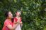 Asian Lovely Girl And Her Mother Blowing Soap Bubbles. Family In