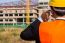 Close Up Young Engineer Wearing A Orange Shirt Stands Talking On