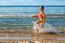 Happy Little Girl Making Splashes On The Beach