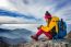 Young Woman Sitting On The Hill Of High Mountains