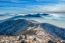 Professional Photographer Takes Photos With Camera On Tripod On Rocky Peak At Sunset