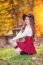 Young Woman With Autumn Leaves In Maple Garden