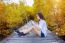 Girl Sitting Alone And Hand Holding Camera On A The Wooden Bridge In Autumn