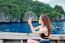 Young Woman Taking Photo Of Beautiful Sea On Camera