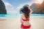 Young Woman In Red Bikini Sitting On The Beach