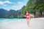 Young Woman In Red Bikini Sitting On The Beach