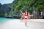 Young Woman In Red Bikini Sitting On The Beach