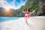 Young Woman In Red Bikini Sitting On The Beach