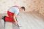 Handyman Laying Down Laminate Flooring Boards