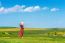 Woman Standing On Green Grass In Green Tea Field