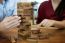 Business Man Placing Wooden Block On A Tower Concept Of Risk Con