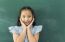 Little Asian Girl With Hands Close To Face Smiling Looking At Camera