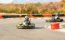 Little Girls Are Driving Go- Kart Car In A Playground Racing Track