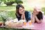 Two Asian Girlfriends Lying On The Lawn, Women In Park During Th