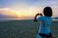 Woman Tourist Taking Photo On The Beach