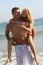 Couple Piggyback Ride At Beach