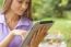 Woman With Tablet Computer In Park