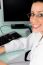 Female Doctor Seated Beside Desktop